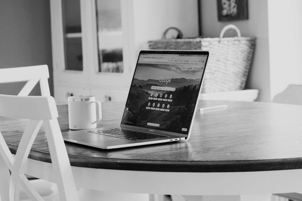 computer on a table with a coffee cup