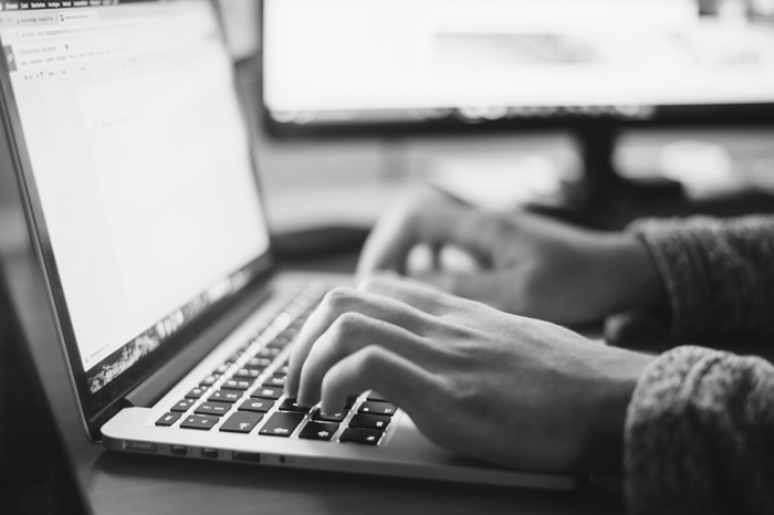 webmaster typing on laptop